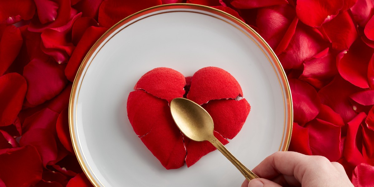 Heart shaped dessert cracked with a golden spoon