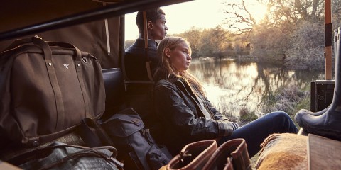 Couple in Barbour clothing enjoying the view from a car