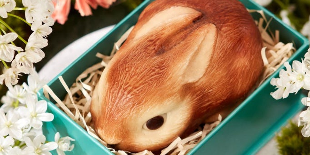 Realistic chocolate rabbit in a box with straw
