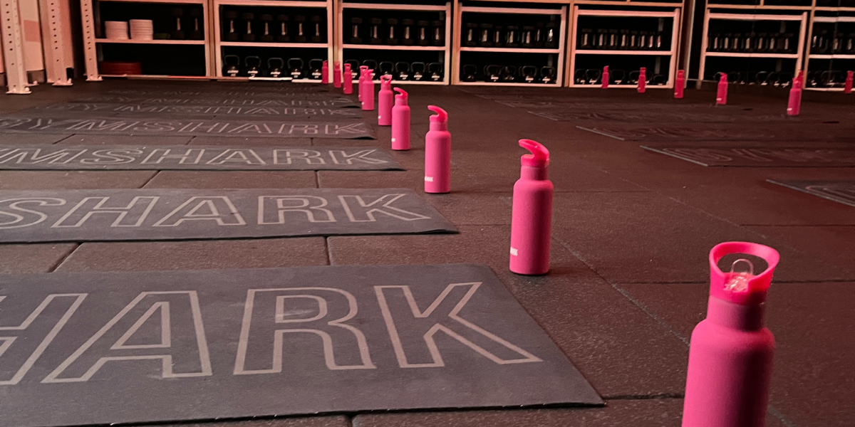 Gymshark workout mats and water bottles arranged on the gym floor