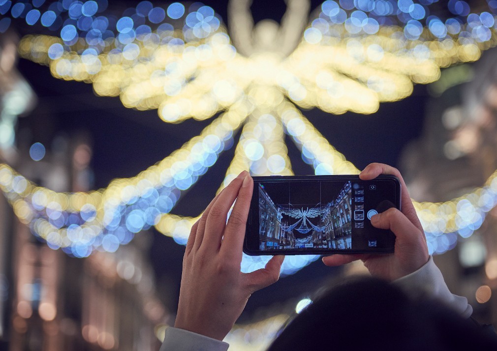 Person taking a photo of the christmas lights on their phone