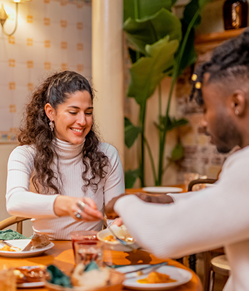 man and woman eating at table in restaurant  