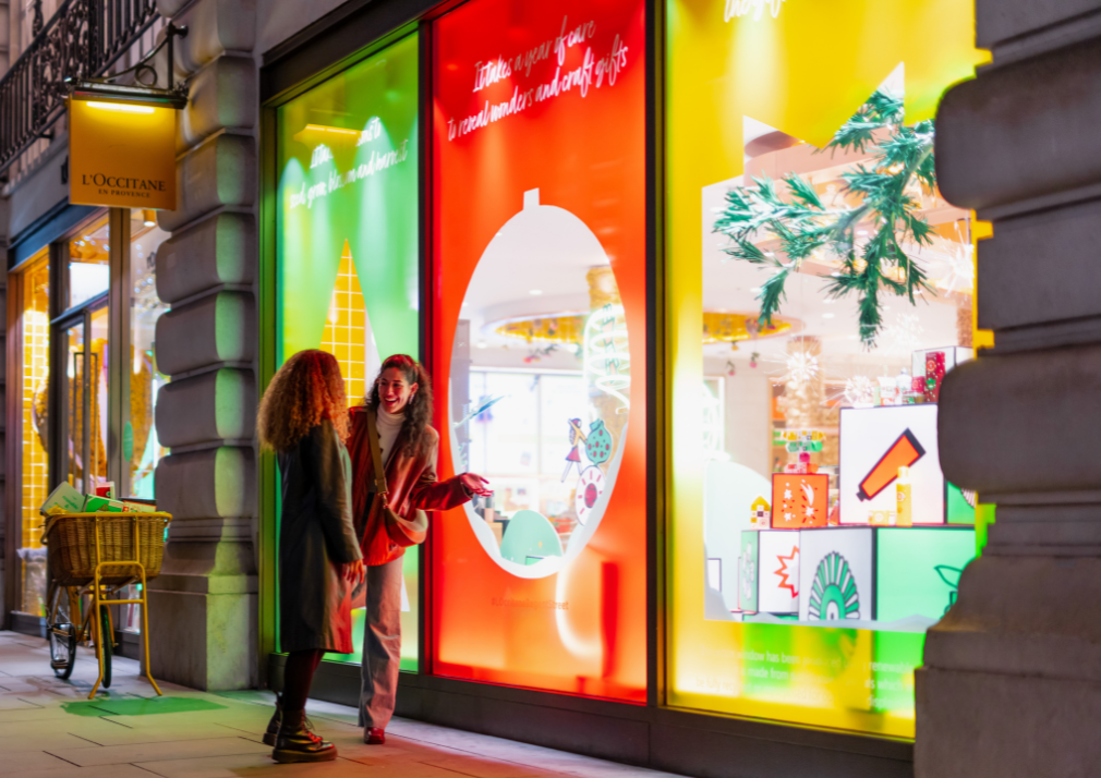 two girls looking at a colour L'occitane window