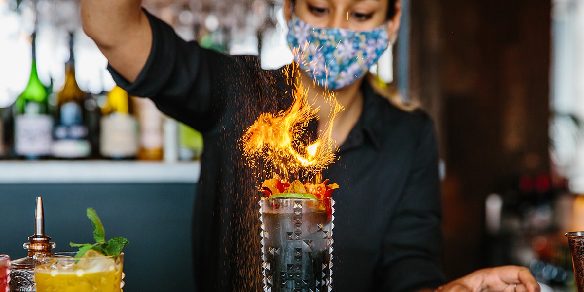 woman making cocktail with fire