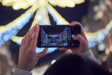 Person taking a photo of the Christmas lights